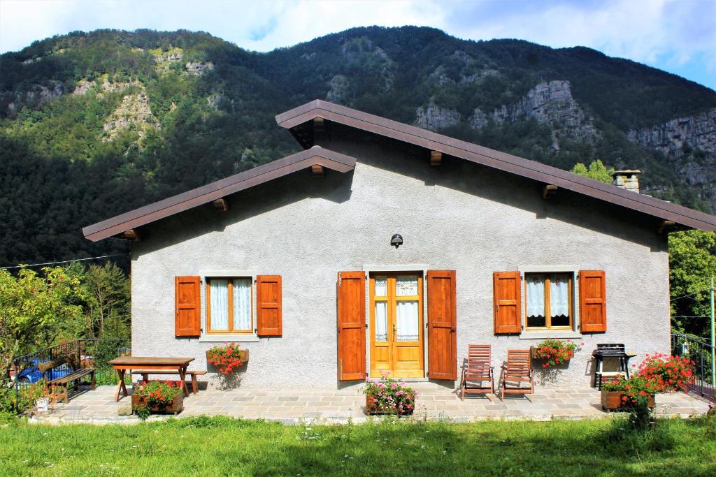 阿贝托内Chalet Abetone in Tuscany的一座带橙色门和桌椅的房子