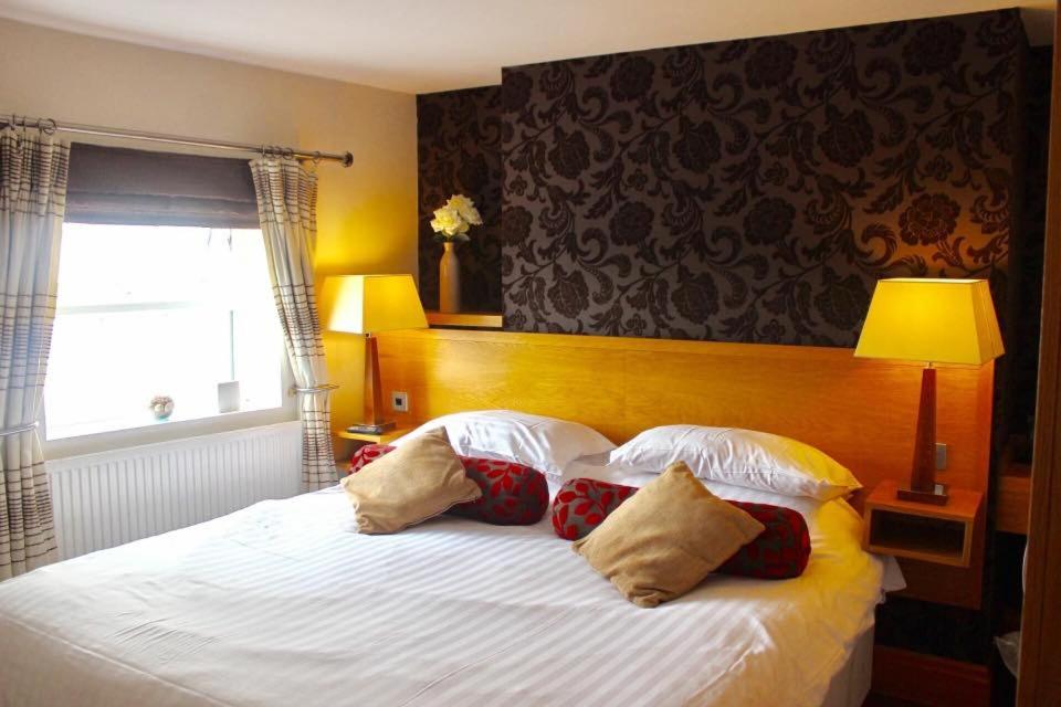 纳尔斯伯勒The Groves Inn的卧室配有带枕头的白色床和窗户。