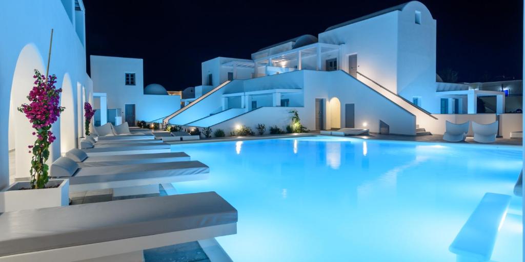 佩里萨安托普拉豪华Spa酒店的一座夜间游泳池,拥有白色的建筑