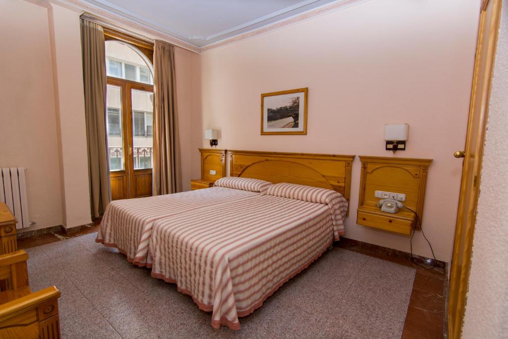 阿尔巴塞特欧罗巴酒店的一间卧室配有带条纹毯子的床