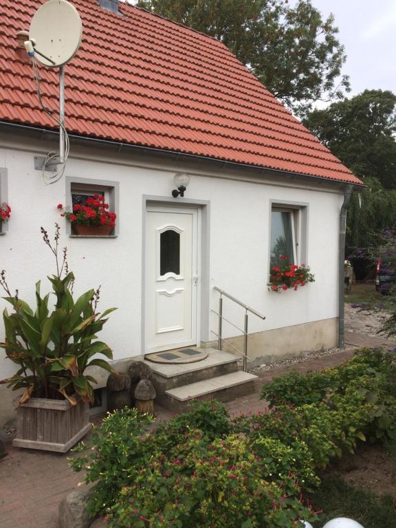 KarnitzFeWo Karnitz/Rügen的一间白色的小房子,有红色的屋顶