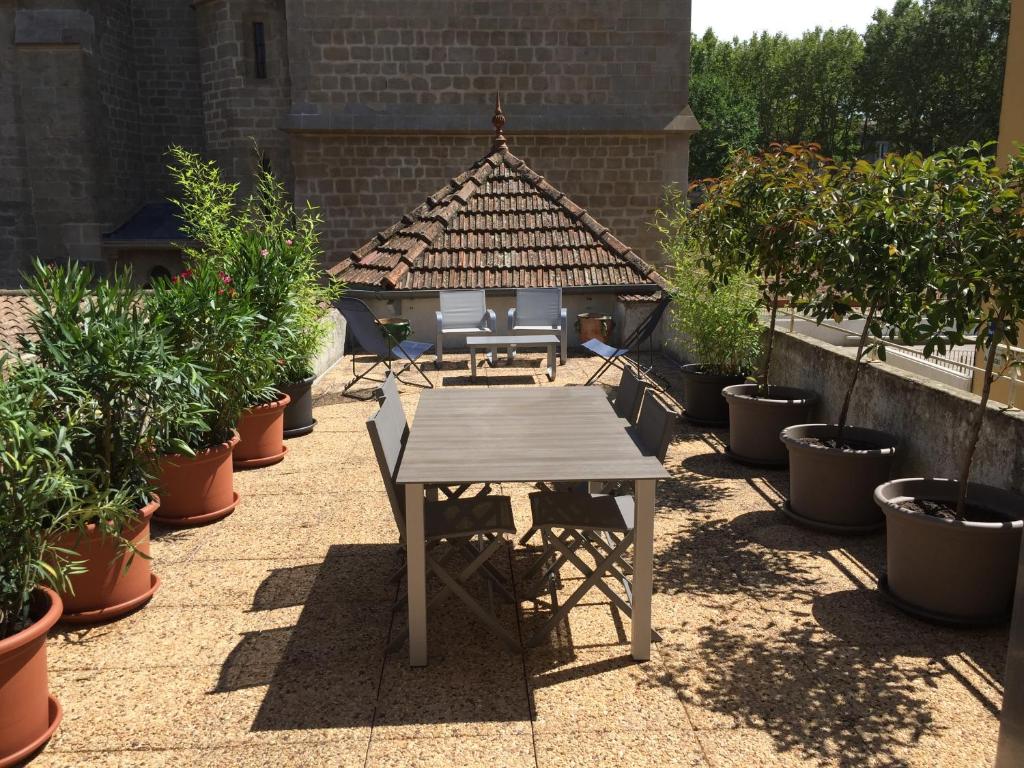 卡尔卡松Apartment La Terasse的花园里种有盆栽植物的桌子