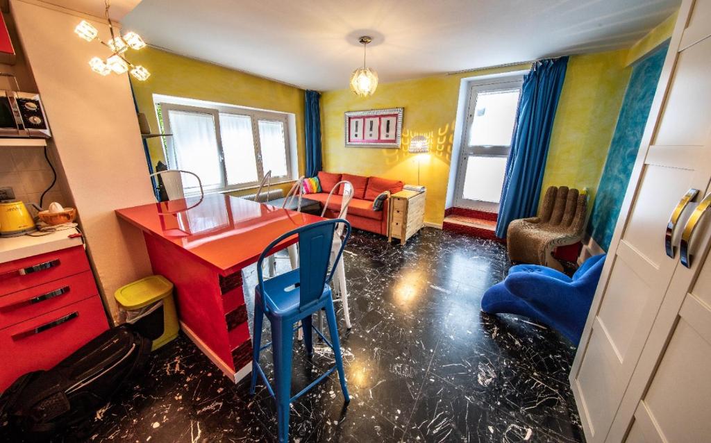 加尔达湖滨思丽维公寓的客厅配有红色的办公桌和沙发。