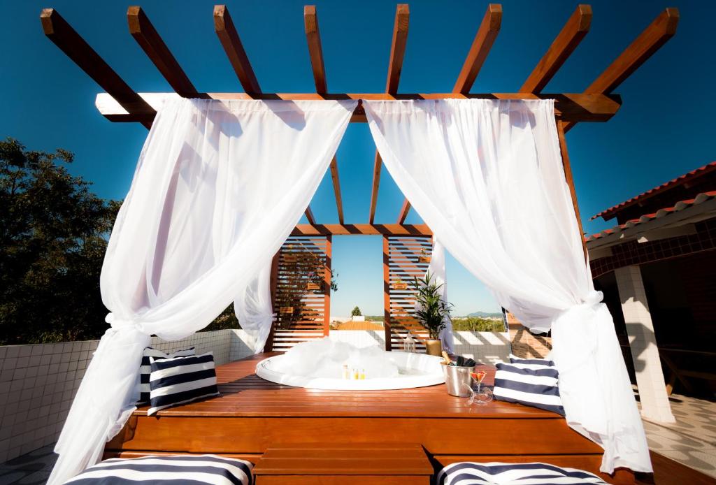 弗洛里亚诺波利斯Mar e Mar Florianópolis的凉亭配有白色窗帘和桌子