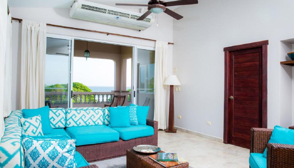 IguanaRio Dulce Ocean View Penthouse V-13的一间带蓝色沙发的客厅和一个阳台