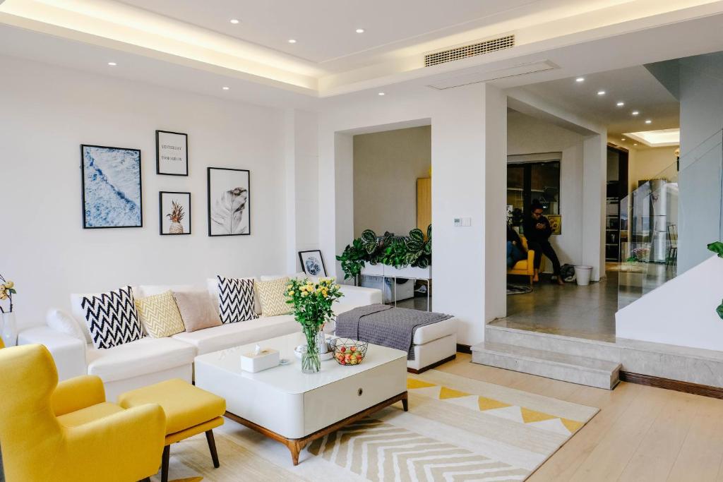 大理大理洱海lila's house海景精品客栈的客厅配有白色沙发和黄色椅子