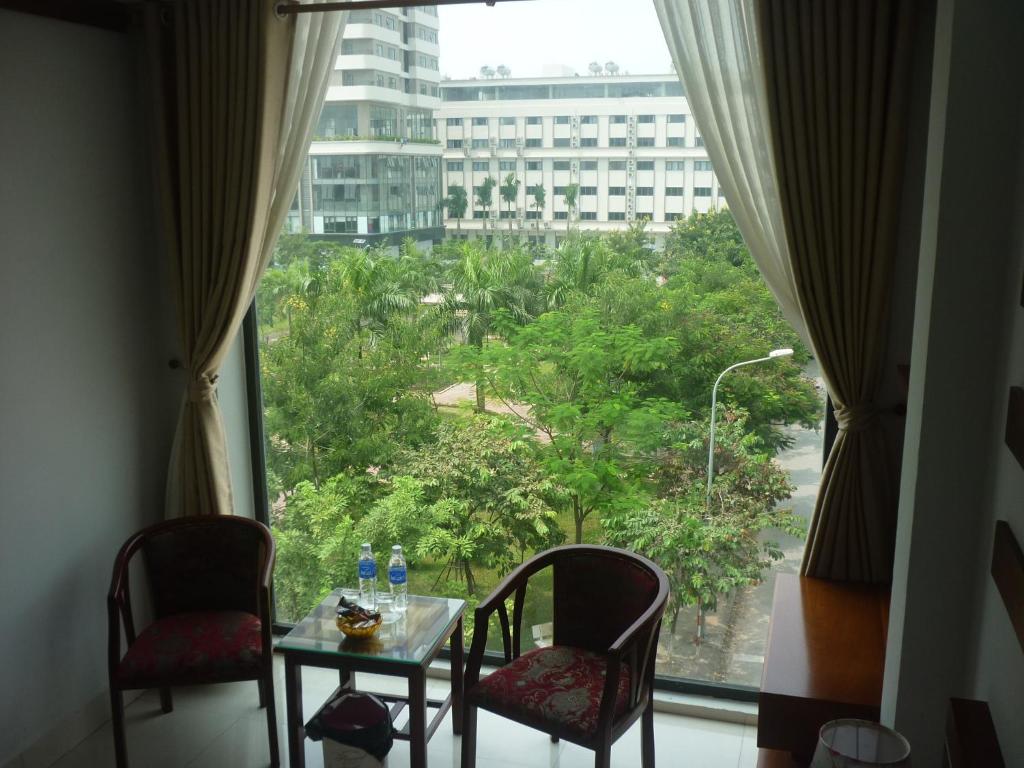 北宁巴宁亚洲公寓酒店的客房设有桌椅和大窗户。