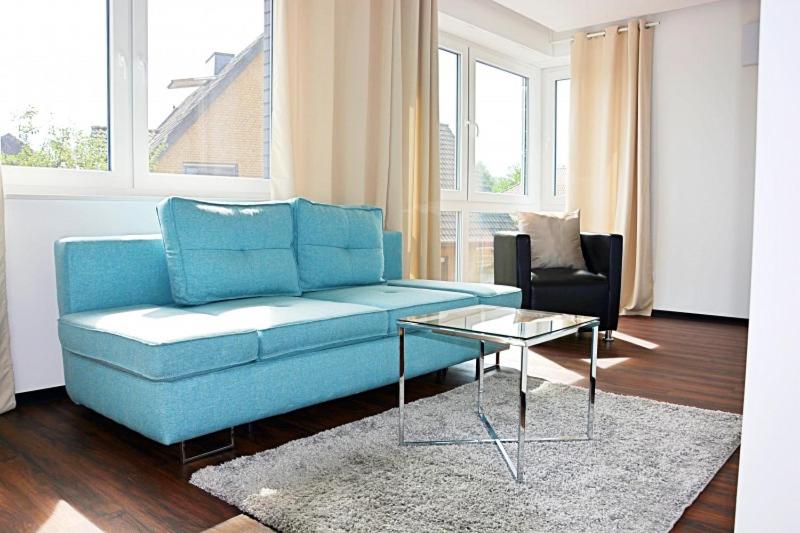 埃姆斯代滕X-Hotel的客厅配有蓝色的沙发和桌子