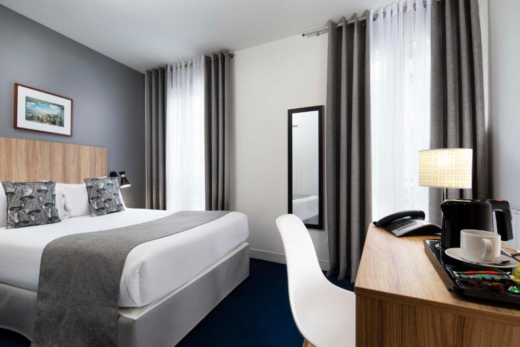 巴黎Hôtel Moulin Vert的配有一张床和一张书桌的酒店客房