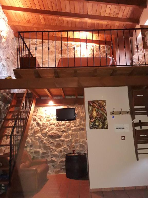 奥伦塞Loft Rural Corte de Fora的石墙客房的一张高架床