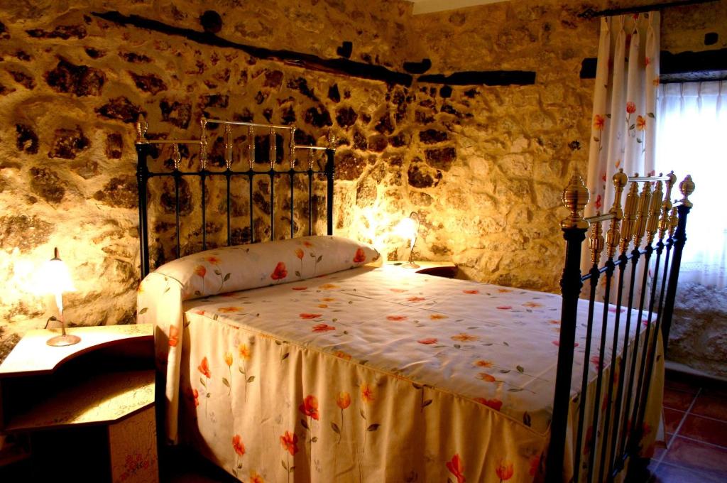 布尔戈斯Casa Rural Valle Esgueva的卧室配有一张石墙床