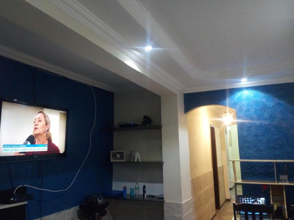 贝洛奥里藏特Pousada Expominas的客厅设有壁挂式平面电视。