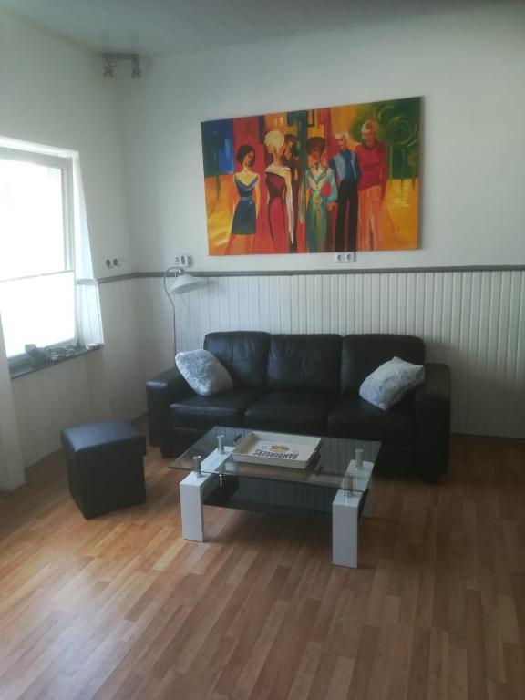 费尔贝特Zentral gelegene Wohnung in Velbert-Mitte的客厅配有黑色沙发和桌子