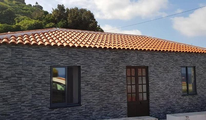 圣克鲁什达什弗洛里什Casa da Cruz的砖屋,有红色屋顶和两扇窗户