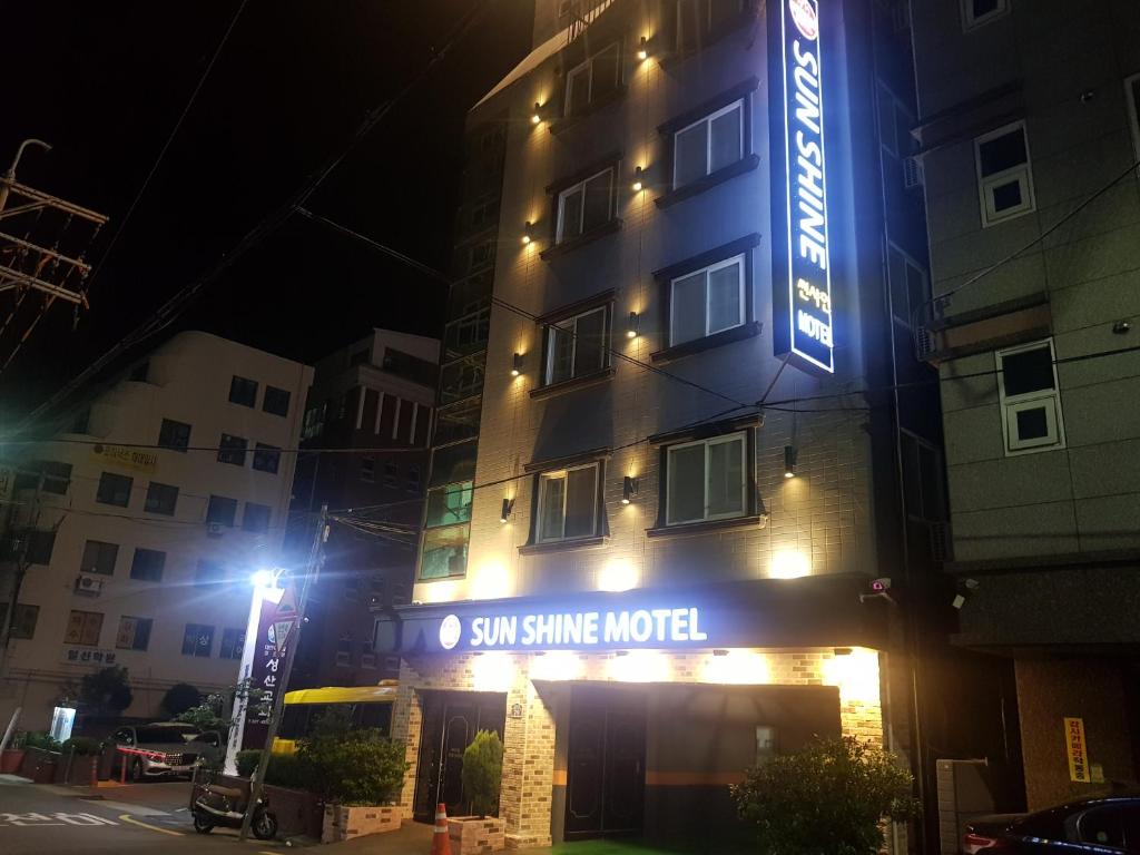 釜山阳光汽车旅馆的一座带有读取阳光明媚的标志的建筑