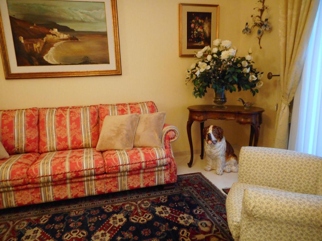 卡塔尼亚adalgisa house的客厅里坐着一只狗,配有沙发和桌子