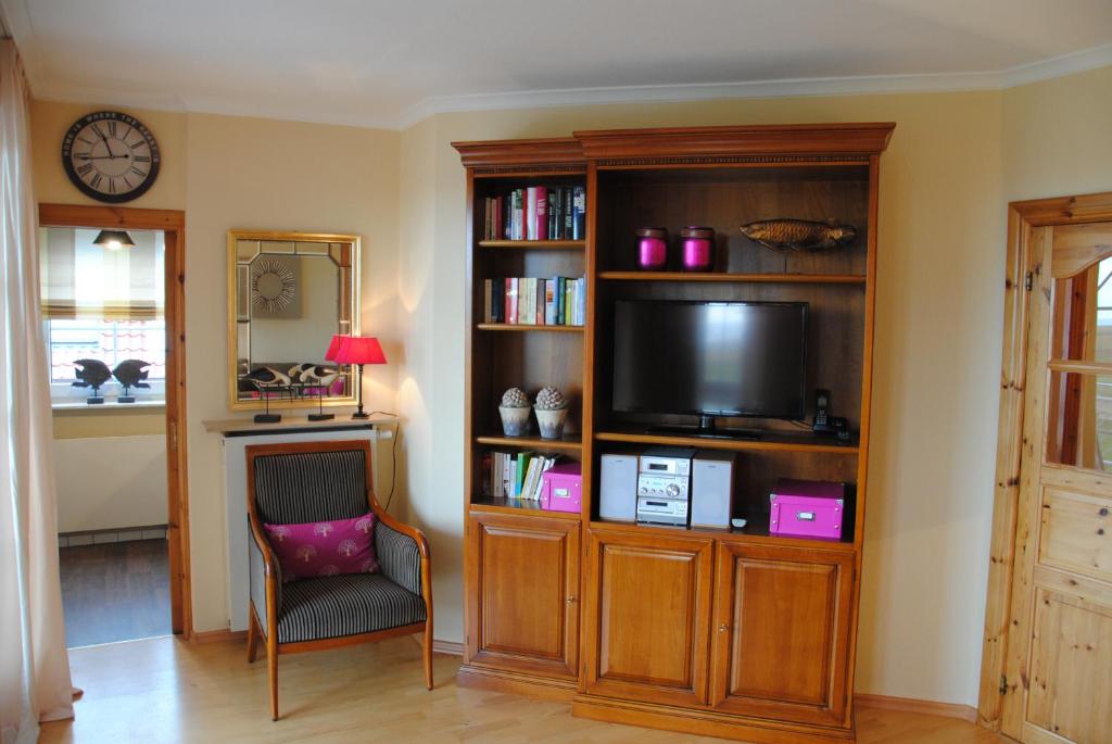 于斯德Inselresidenz Wattenmeer - Wohnung 7的一间客厅,在书架上配有电视
