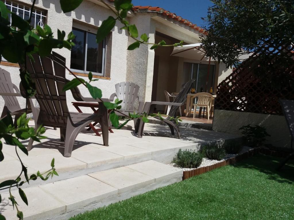 圣普里安海滩Belle villa classée 4 étoiles proche plage avec jardin的坐在房子的院子中的一对椅子
