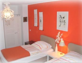 杜塞尔多夫斯缇米尼斯酒店的一间卧室设有橙色墙壁和一张床