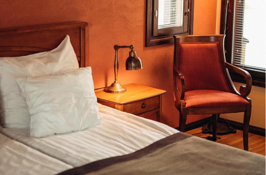 塔库沃里塔库黄金度假村的一间卧室配有一张床、一把椅子和一盏灯