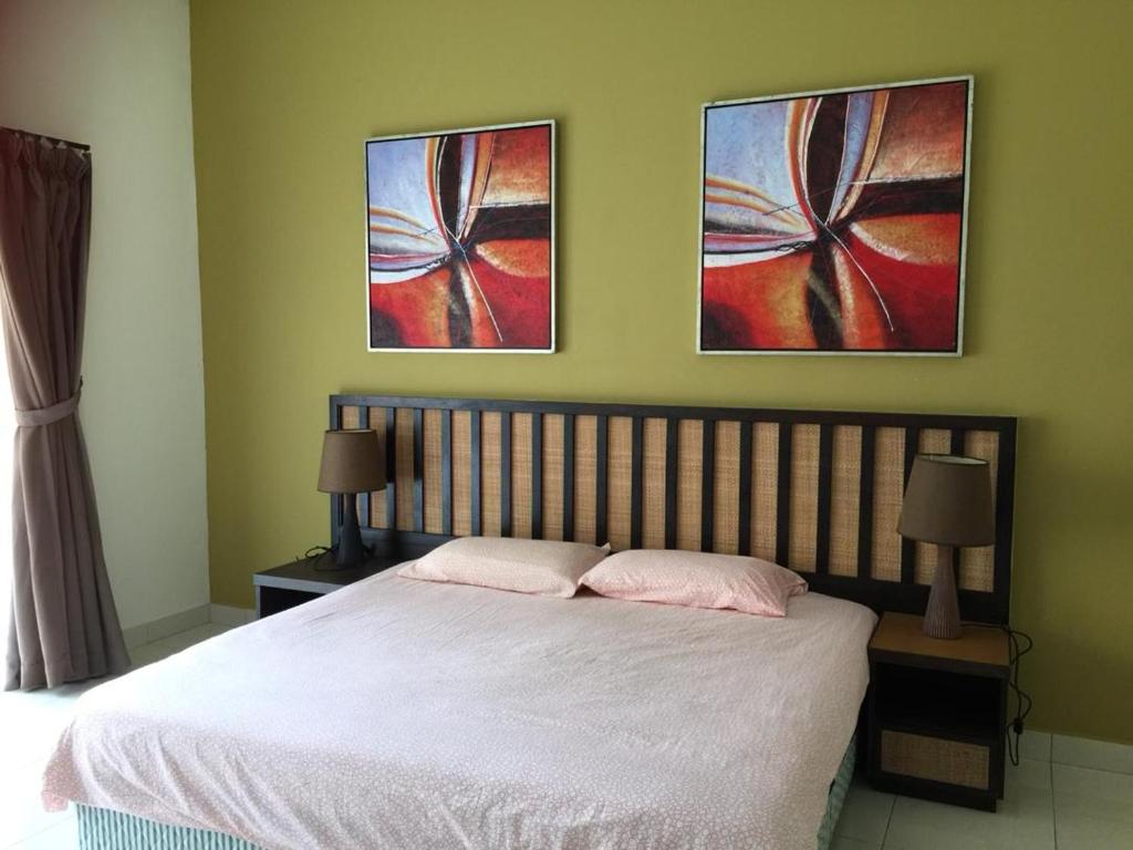 万津Happy Stay @ Morib Gold Coast的卧室配有一张床,墙上挂有两幅画