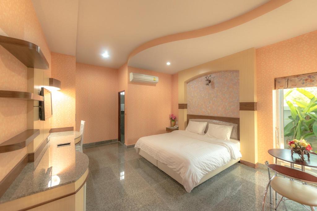 素辇府Martina Hotel Surin的卧室配有白色的床和桌子