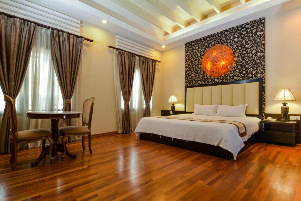 马六甲马六甲鸡场街精品酒店的一间卧室配有一张床、一张桌子和一张桌子