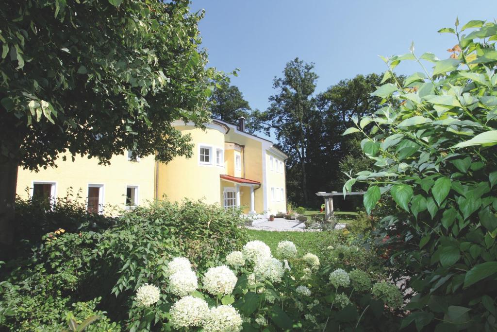 巴特法兴格豪斯黑尔德格德酒店的黄色房子前面的白色花卉花园