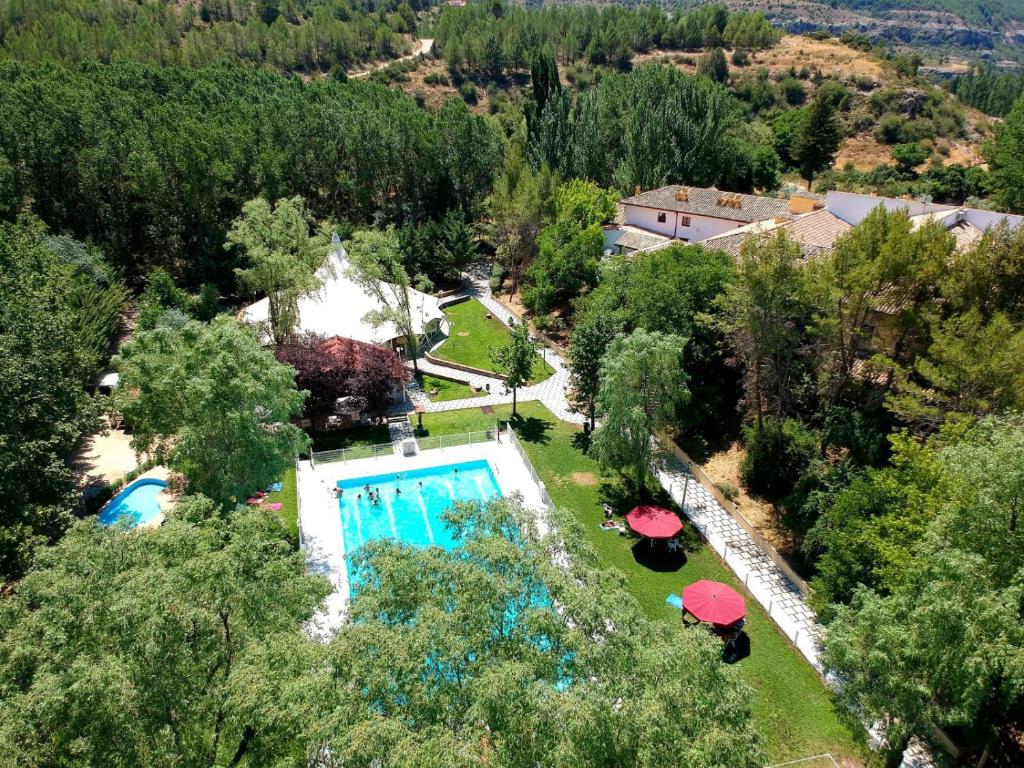 昆卡Hotel Resort Cueva del Fraile的享有带遮阳伞的游泳池的顶部景致