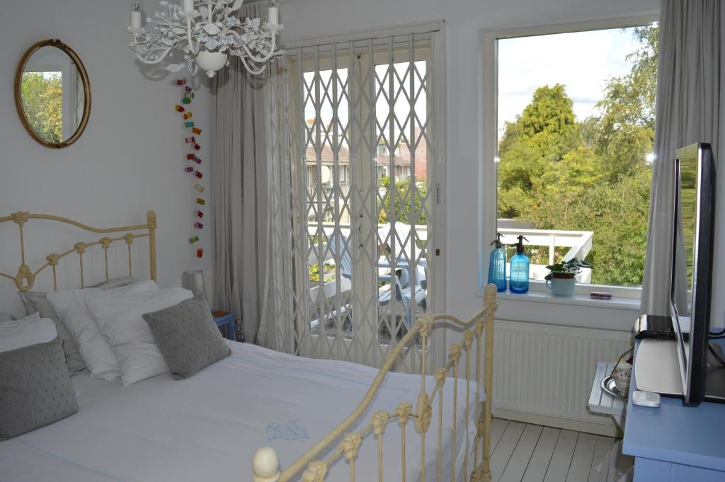 阿姆斯特丹Bed & Breakfast Jo Amsterdam的卧室配有白色的床和窗户。