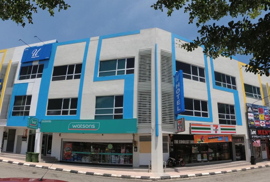 瓜拉立卑U Design Hotel Kuala Lipis的城市街道上的一座蓝白色建筑