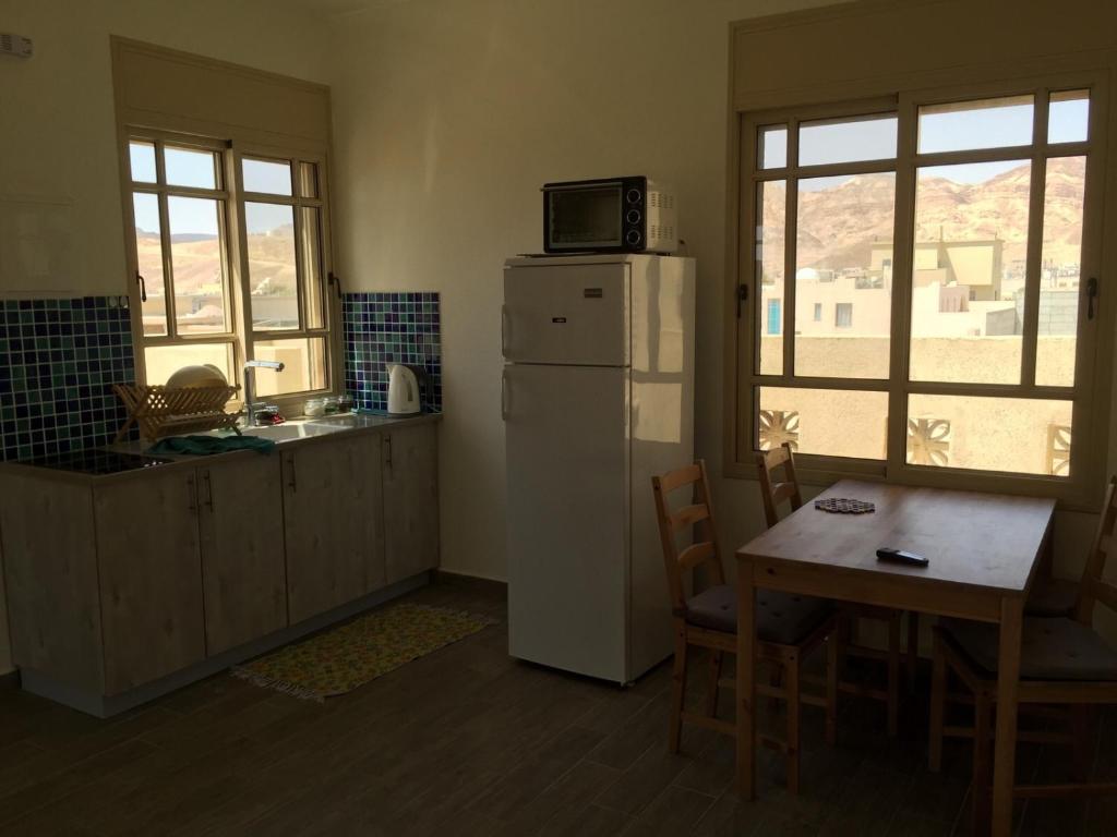 Beʼer OraThe Birdwatchers Nest的厨房配有冰箱和带微波炉的桌子。