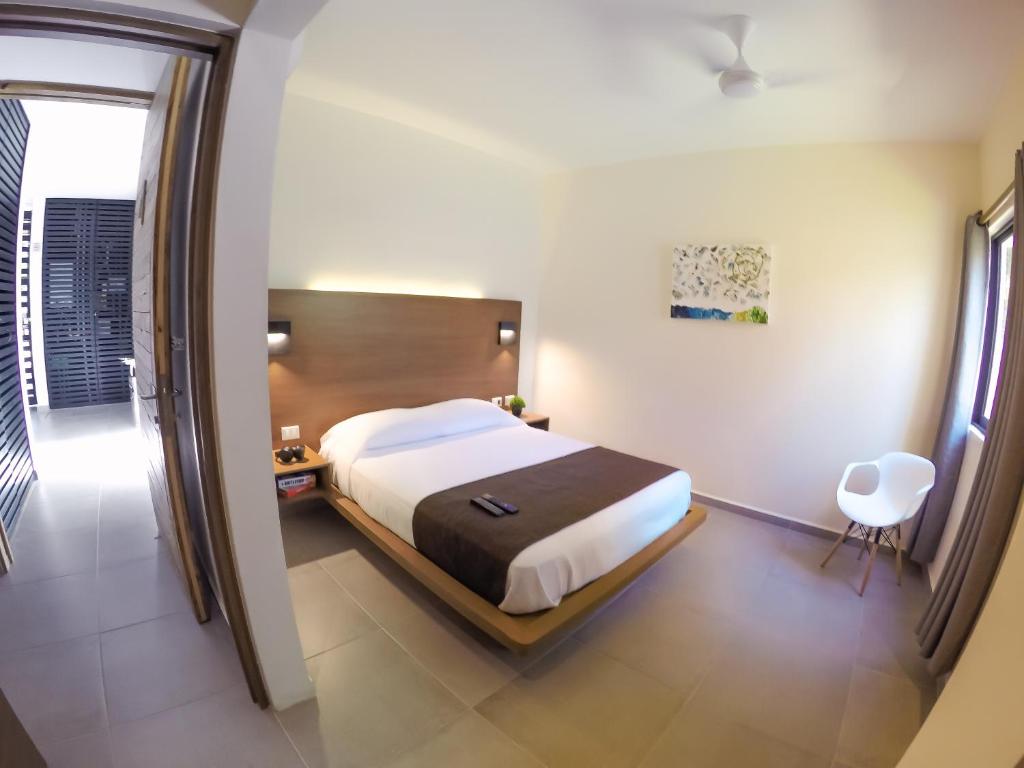 坎昆Viento Suites Cancún的一间卧室配有一张床和一把椅子