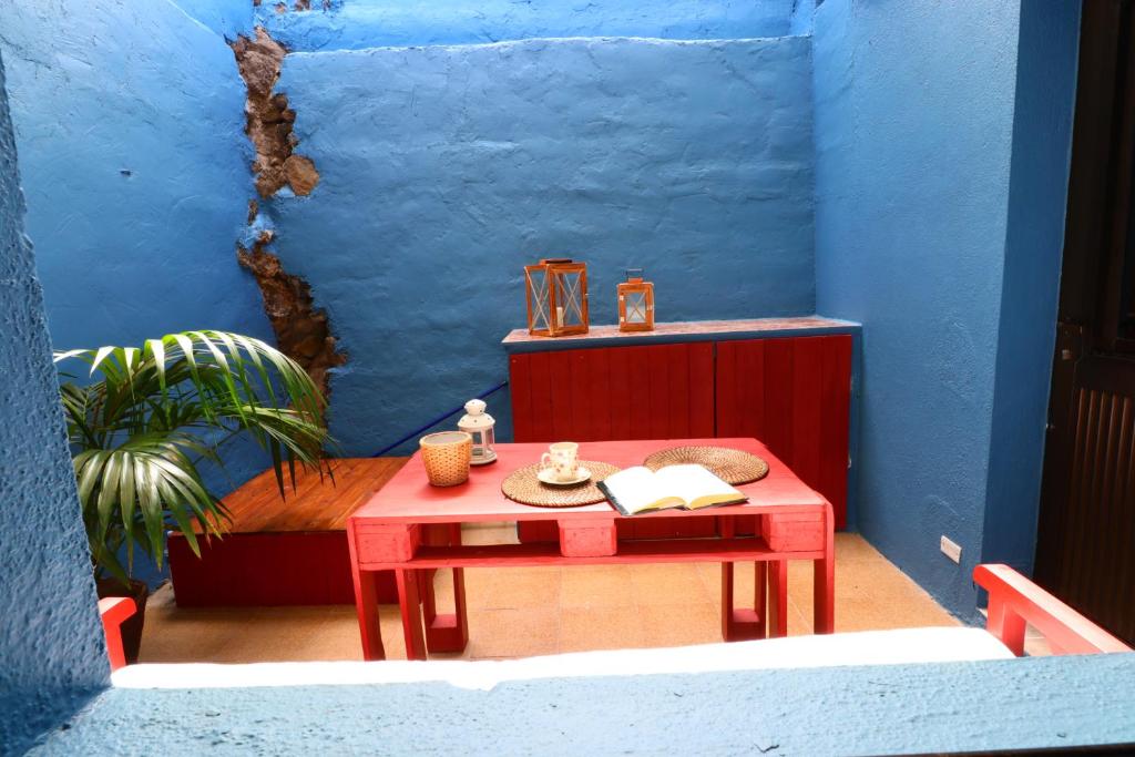 莫卡诺尔Barlovento 41的蓝色墙壁的房间里一张红色的桌子