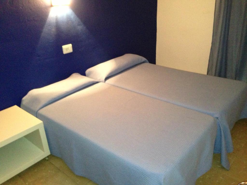 德拉塞尔瓦港德国旅馆的卧室配有白色的床和墙上的灯