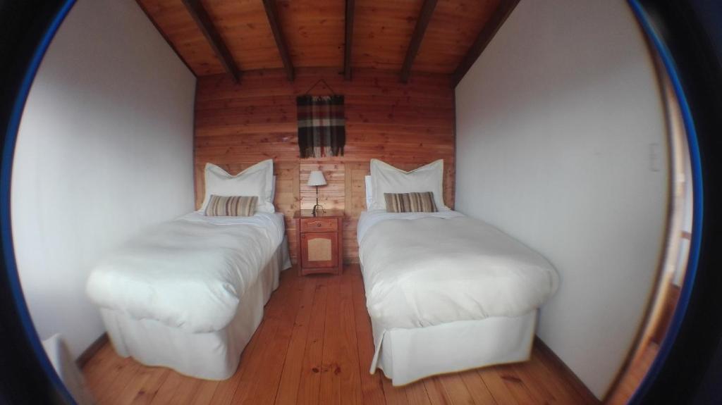La JuntaTerrazas del Palena的配有镜子的客房内的两张床