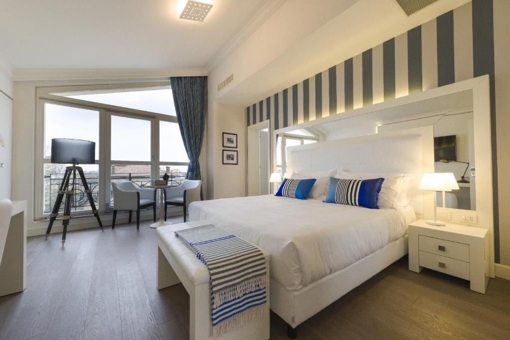 拉文纳帕拉兹贝兹酒店的卧室配有一张白色的大床和一张桌子
