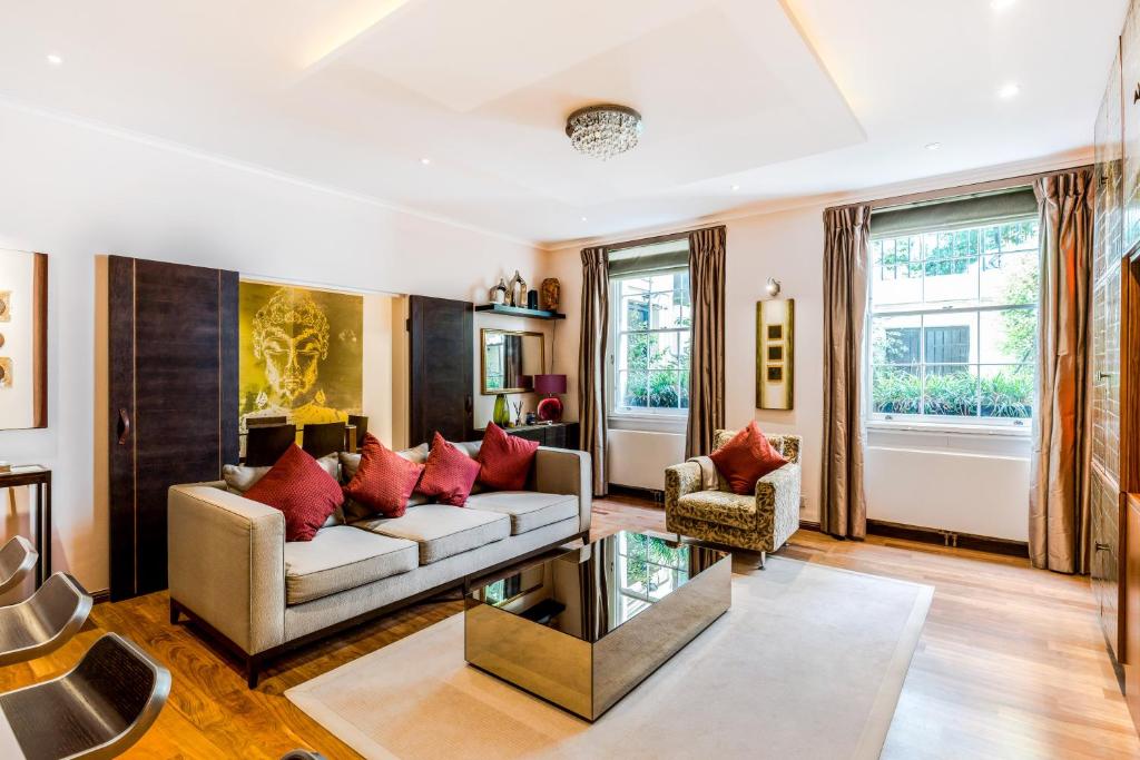 伦敦Garden Apartment in Central London的带沙发和红色枕头的客厅