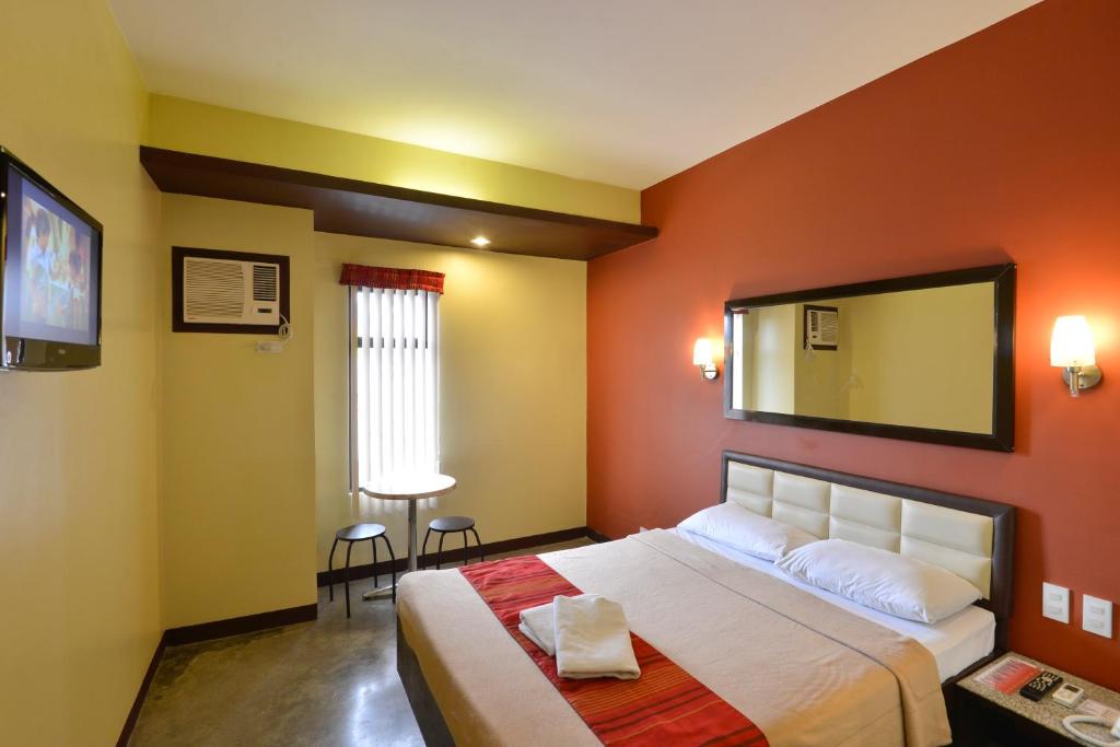 宿务Express Inn Cebu Mabolo的一间卧室配有一张大床和镜子