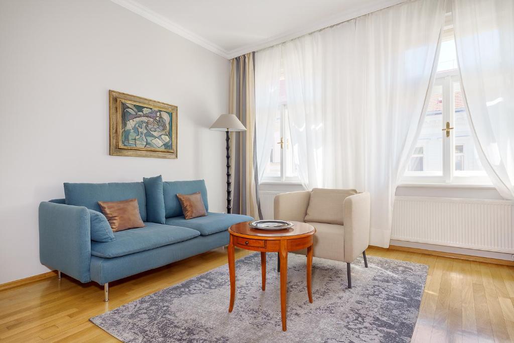 布拉格汉葛牆公寓的客厅配有蓝色的沙发和桌子