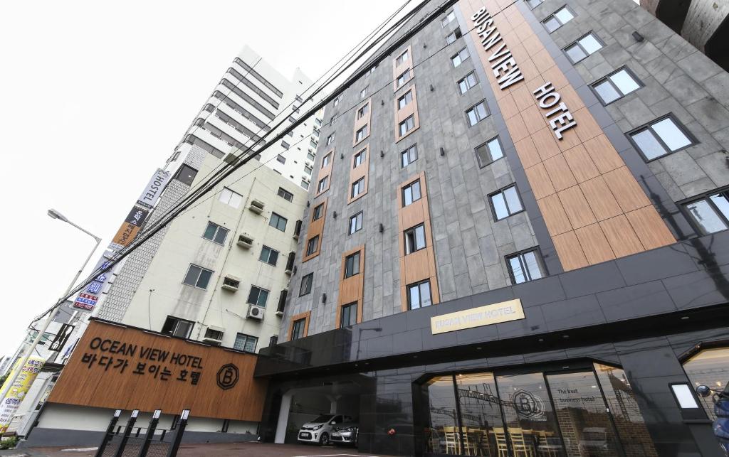 釜山Busan Station BUSAN VIEW HOTEL的一座高大的建筑,前面有标志