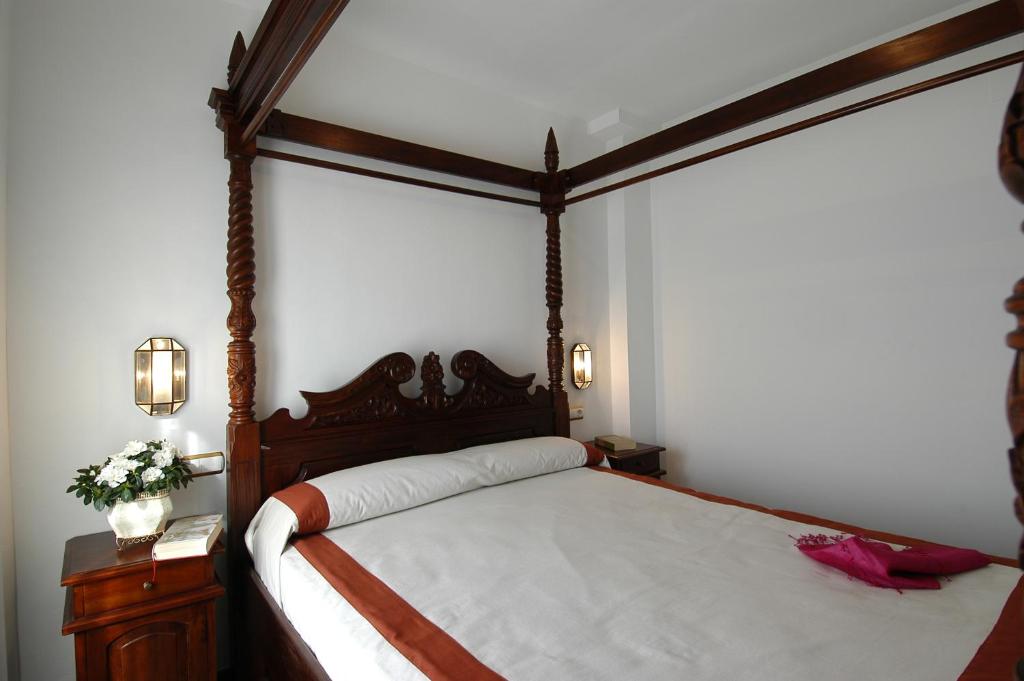阿尔姆尼卡厄尔特兰克德尔马尔公寓式酒店的一间卧室设有天蓬床和2个床头柜。