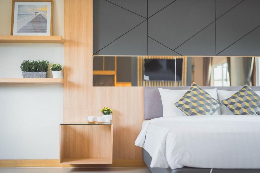 纳泰海滩APA-大树精品酒店的卧室设有白色的床和木墙