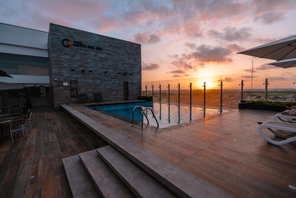 通贝斯太阳海岸温德姆通贝斯酒店的一座享有日落美景的建筑中的游泳池
