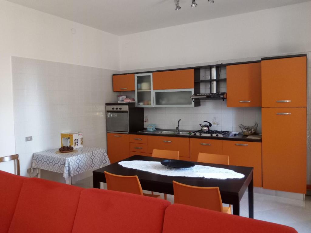 布林迪西Casa Paradiso的厨房配有橙色橱柜和桌椅