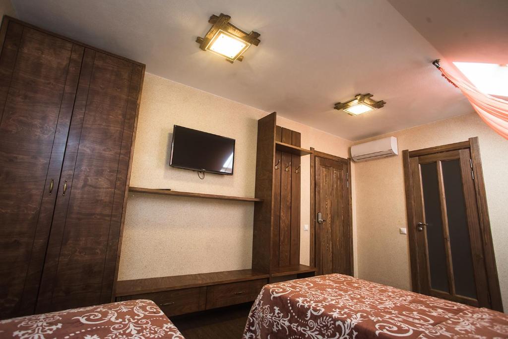 伊热夫斯克Russkiy dvor的卧室配有一张床,墙上配有电视。