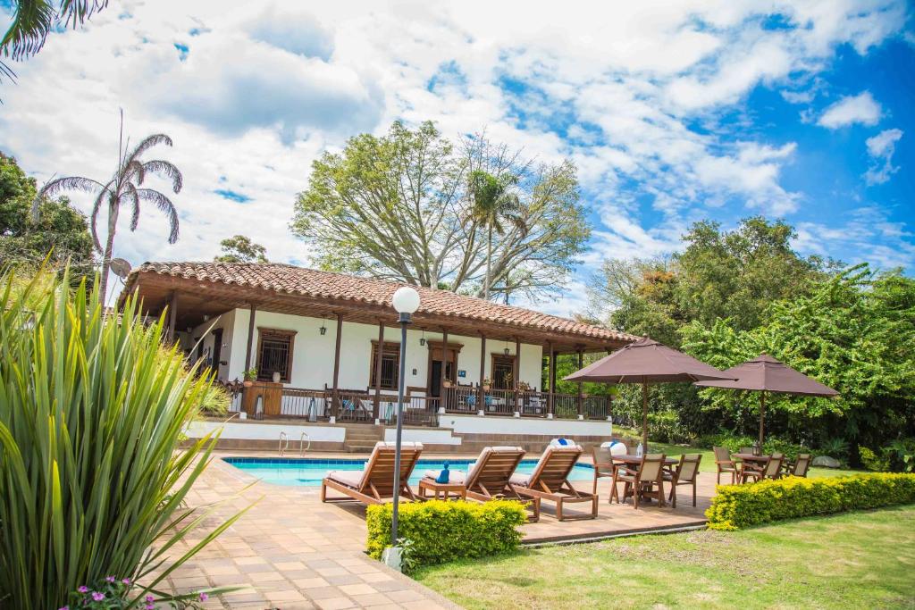蒙特内哥罗Hotel Delirio Campestre的别墅设有游泳池和庭院家具。