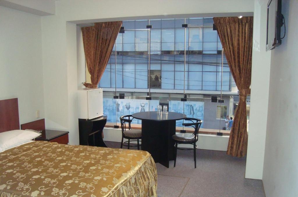 利马Hostal Bond的客房设有床、桌子和窗户。