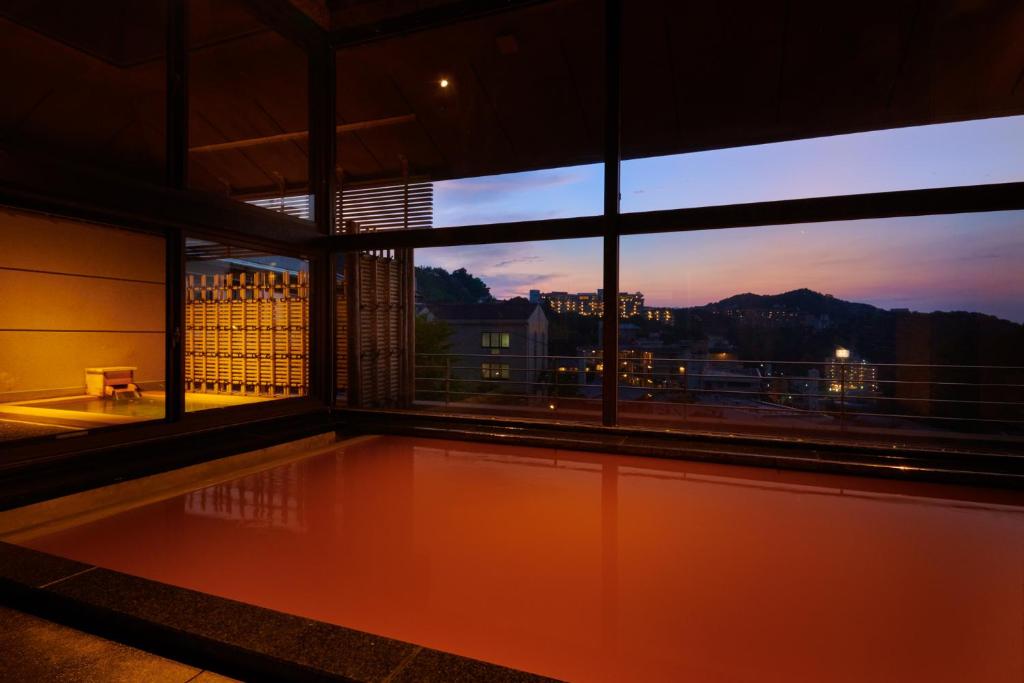 神户有马温泉高山庄华野酒店的客房设有带游泳池的大窗户。