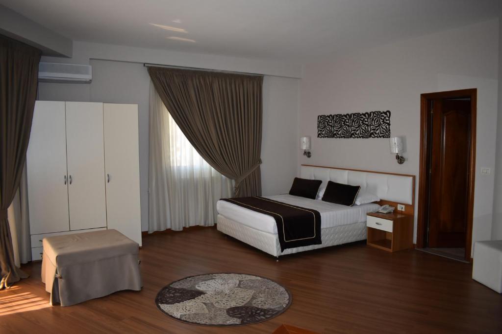 都拉斯阿尔维酒店的酒店客房配有一张床铺和一张桌子。